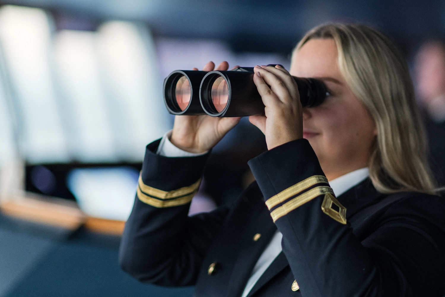 2. styrmann som ser i en kikkert på broen